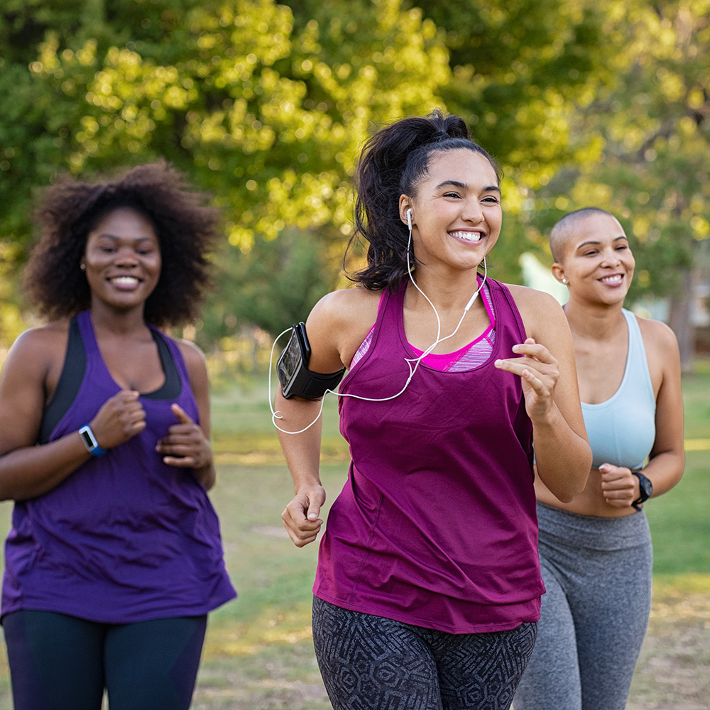 A group of women jogging in a park.