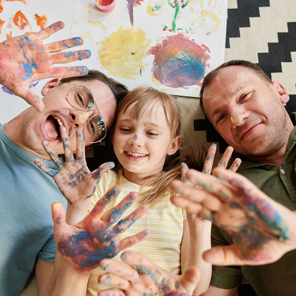 A man and a girl with paint on their hands.