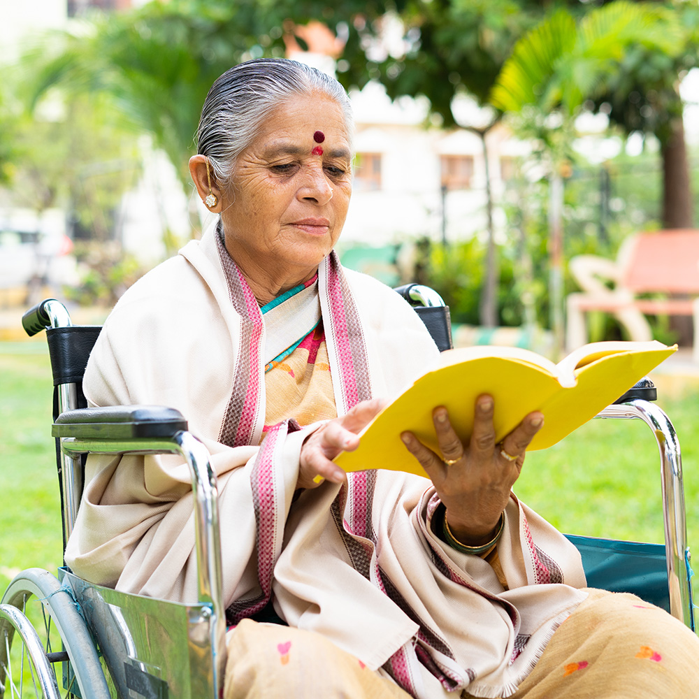 A woman in a wheelchair reading a book.