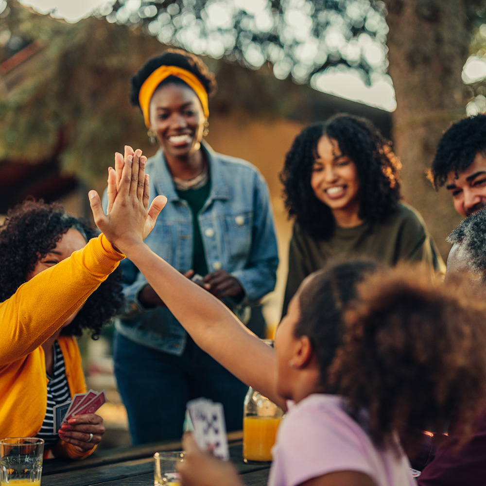 A group of people high fiving each other at a picnic table.