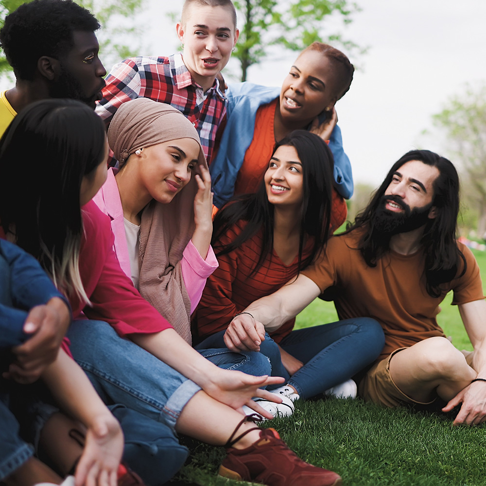 A group of young people sitting on the grass.
