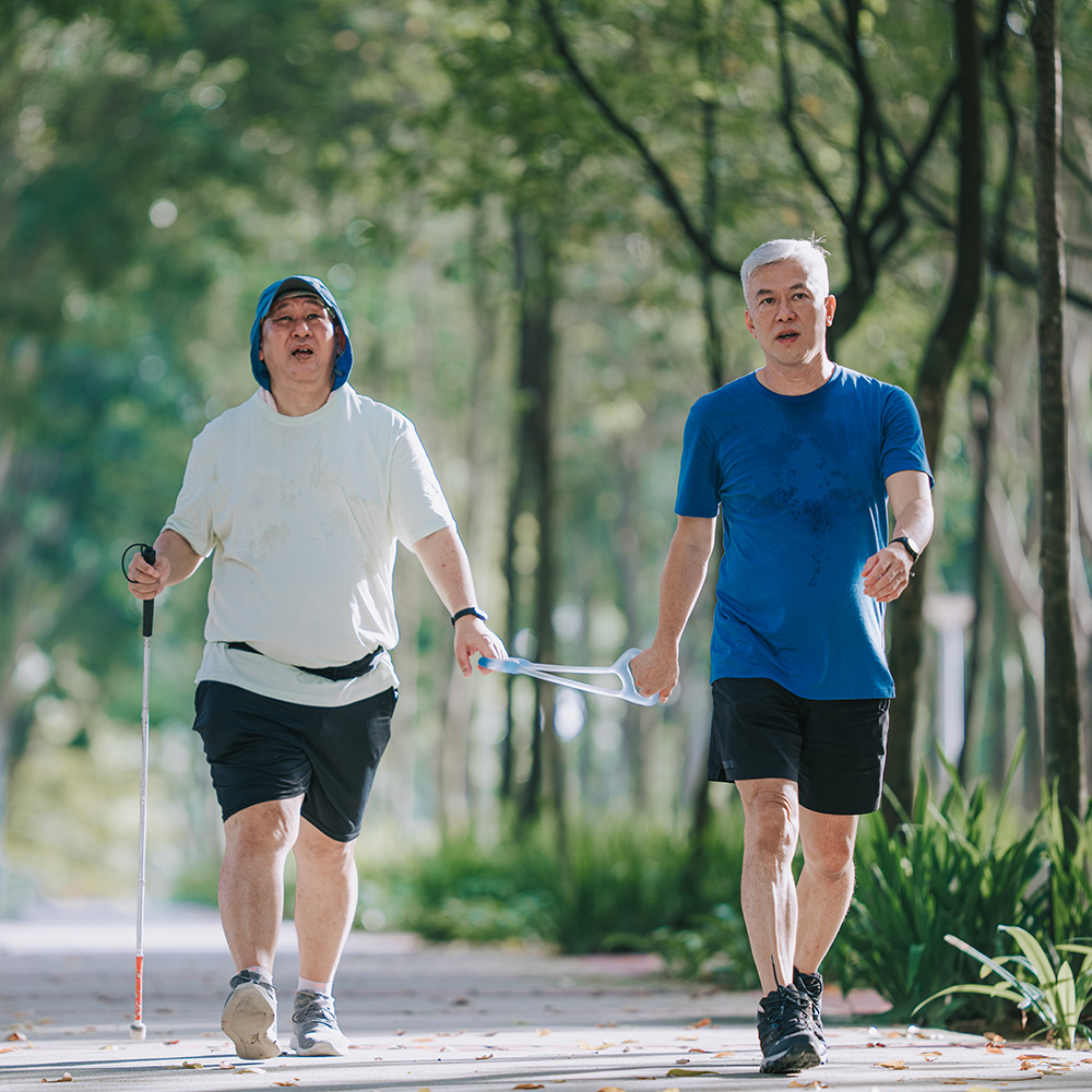 Two older men walking together in a park.